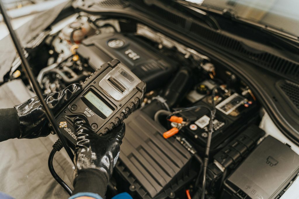 pexels photo 13065692 13065692 Mechanic diagnosing a car engine with a diagnostic tool, showcasing technical expertise and automotive care.