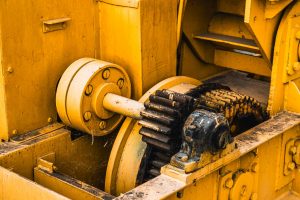 Detailed view of industrial machinery showcasing yellow painted metal gears and components.