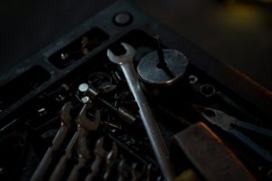 A detailed view of assorted tools and wrenches in a dimly lit workshop environment.