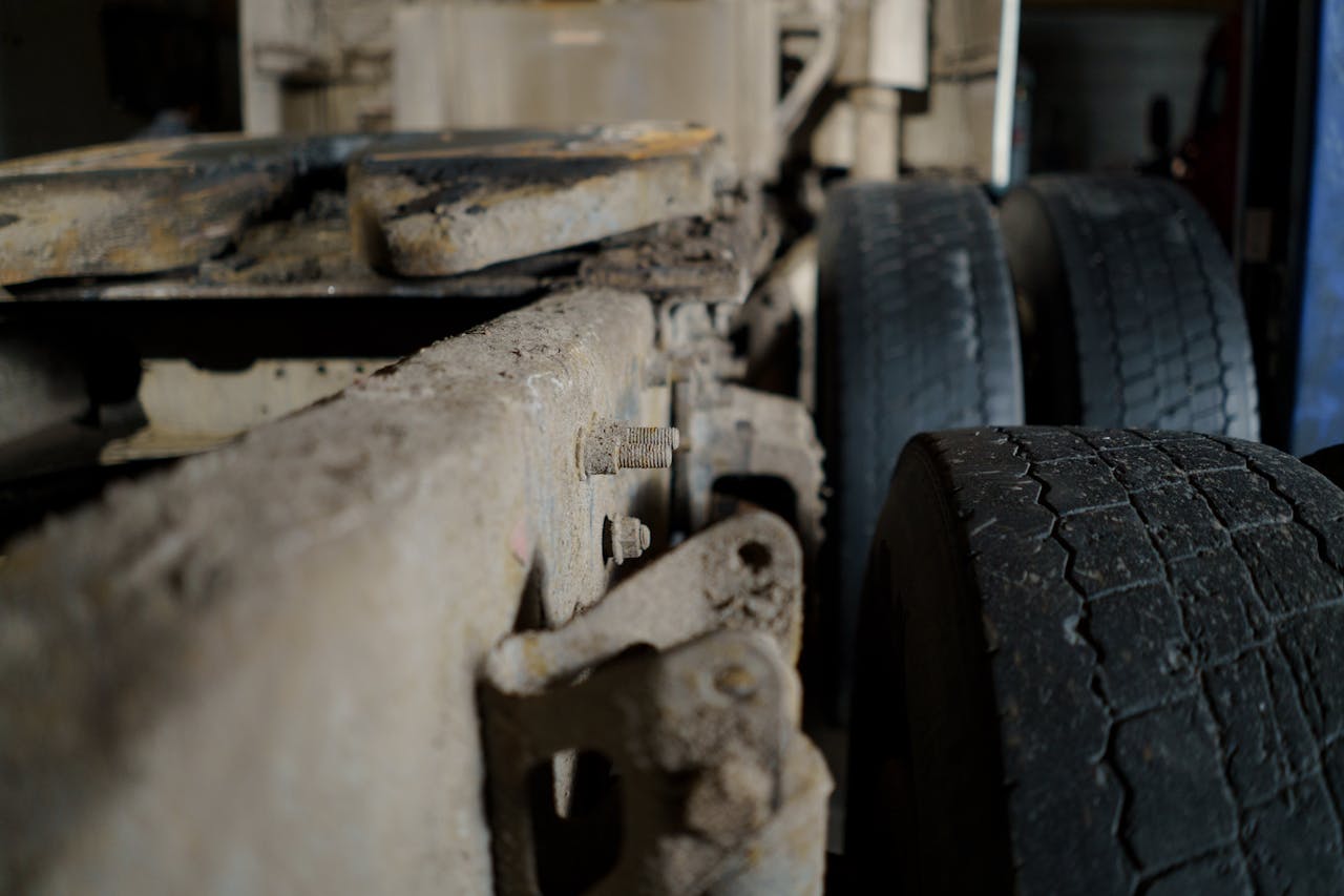 Detailed close-up of a dirty truck chassis and tires, showcasing automotive machinery.